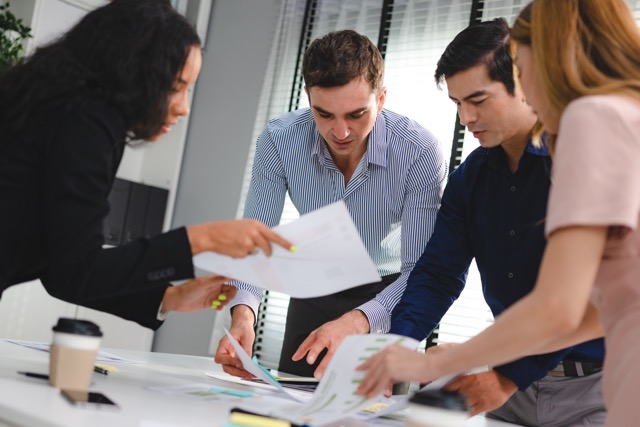 A diverse group of people working together in a modern office setting.