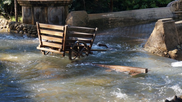 A flooded street with a cart submerged in water.