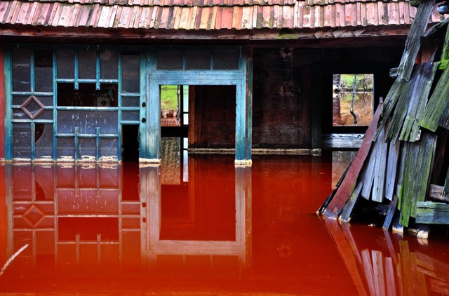 A building half-submerged in floodwaters.